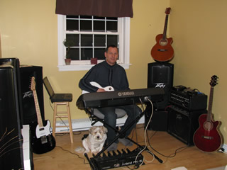 Manse playing guitar at his keyboard